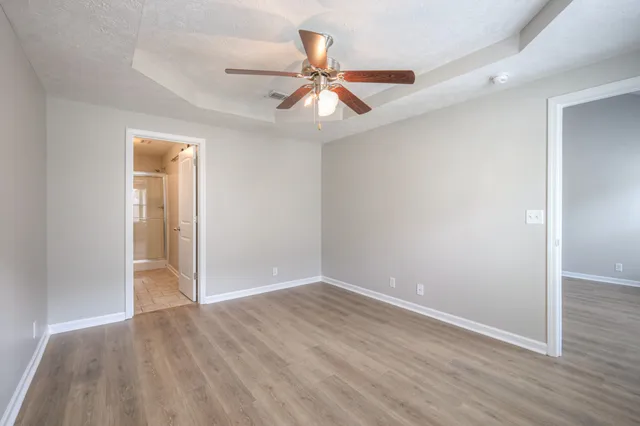 an empty room with wooden floor and windows