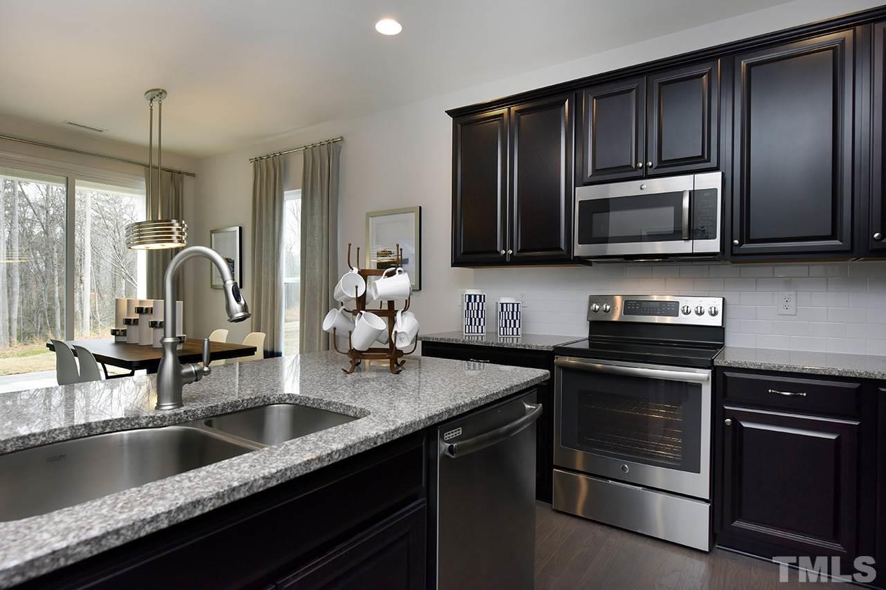 2567 Rambling Creek Road, Unit HOMESITE 14 Apex, NC 27523 - Photo 3 of 19 Photo is of Decorated Model Home at Woodcreek. Subject home has white cabinetry and gas stove.