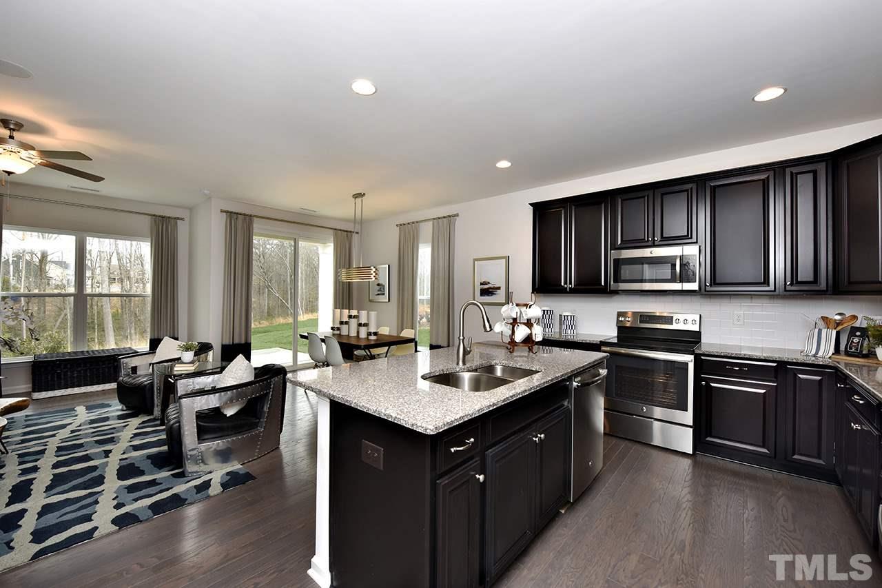 2567 Rambling Creek Road, Unit HOMESITE 14 Apex, NC 27523 - Photo 6 of 19 Photo is of Decorated Model Home at Woodcreek. Subject home has white cabinetry and gas stove.