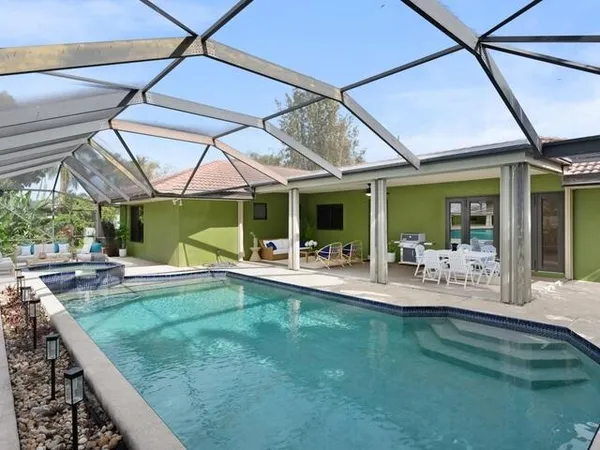 a view of a swimming pool with a patio and a yard