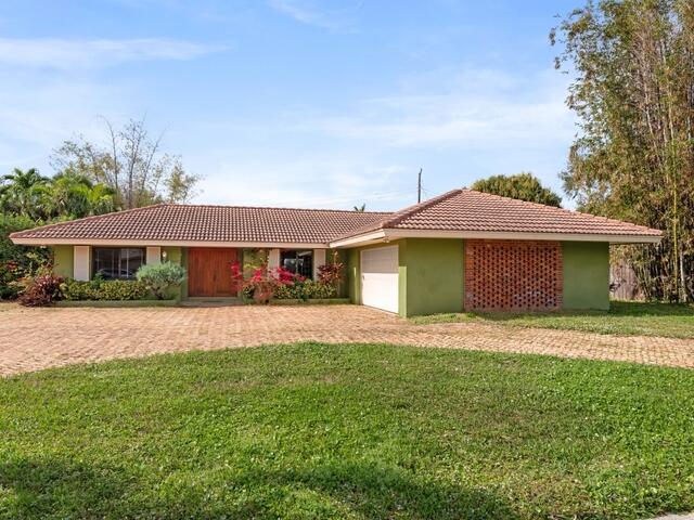 1705 Ashby Road Juno Beach, FL 33408 - Photo 19 of 21 a front view of a house with a yard and garage