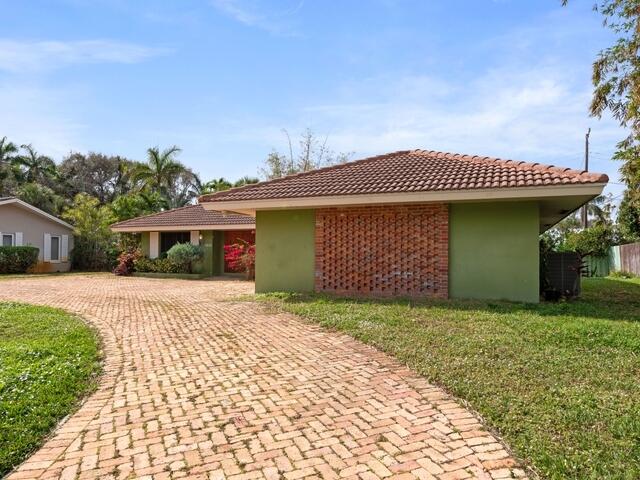 1705 Ashby Road Juno Beach, FL 33408 - Photo 21 of 21 a front view of a house with a garden