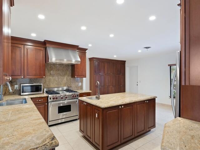 1705 Ashby Road Juno Beach, FL 33408 - Photo 6 of 21 a kitchen with a stove sink and cabinets