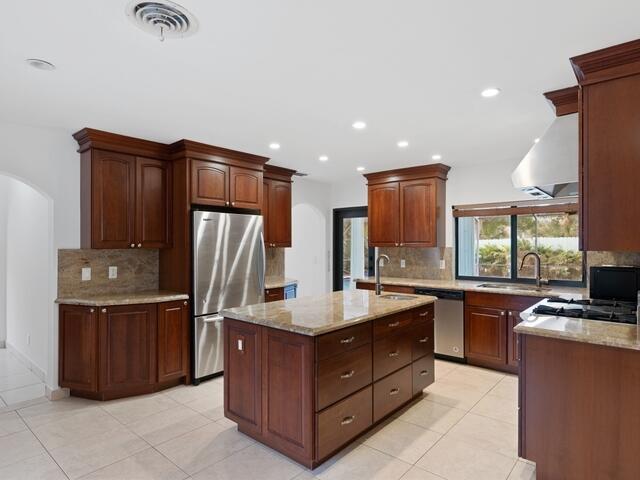 1705 Ashby Road Juno Beach, FL 33408 - Photo 7 of 21 a kitchen with stainless steel appliances granite countertop a stove refrigerator and cabinets