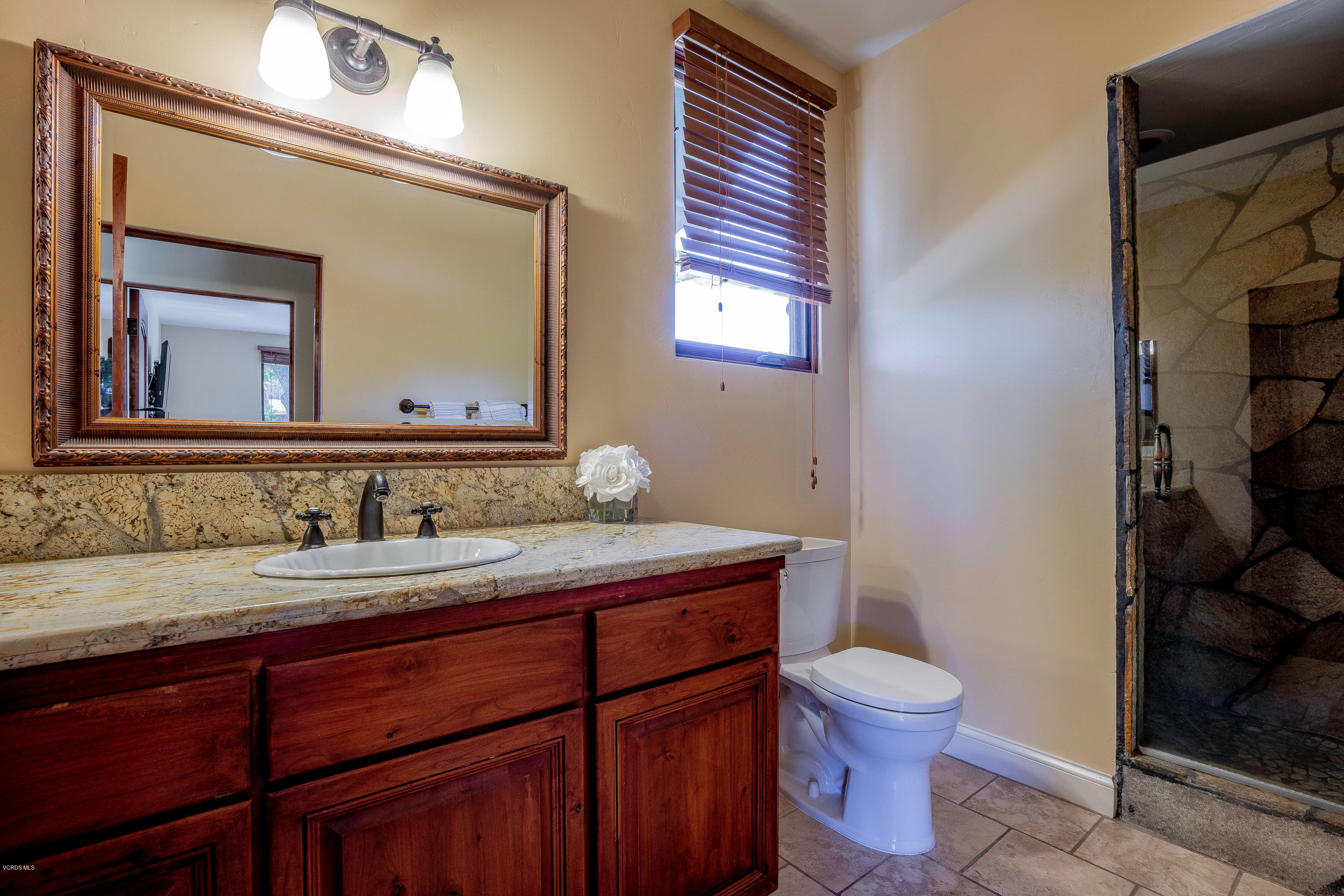 525 Rimrock Road Thousand Oaks, CA 91361 - Photo 79 of 95 a bathroom with a granite countertop toilet sink and mirror