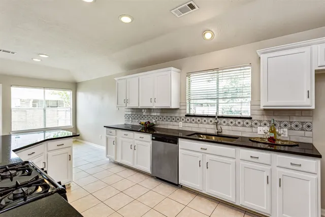 a kitchen with stainless steel appliances granite countertop a sink stove and cabinets