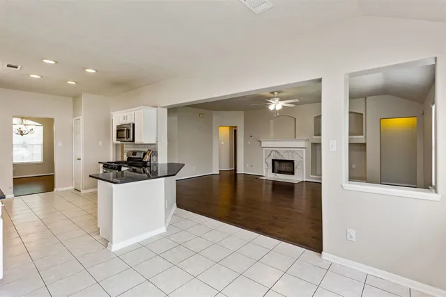 a kitchen with granite countertop white cabinets and stainless steel appliances