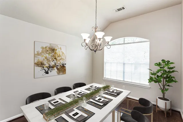 a view of a dining room with furniture and a chandelier