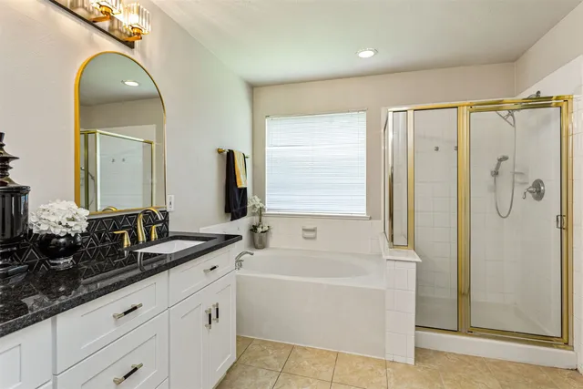 a bathroom with a double vanity sink and mirror with bathtub