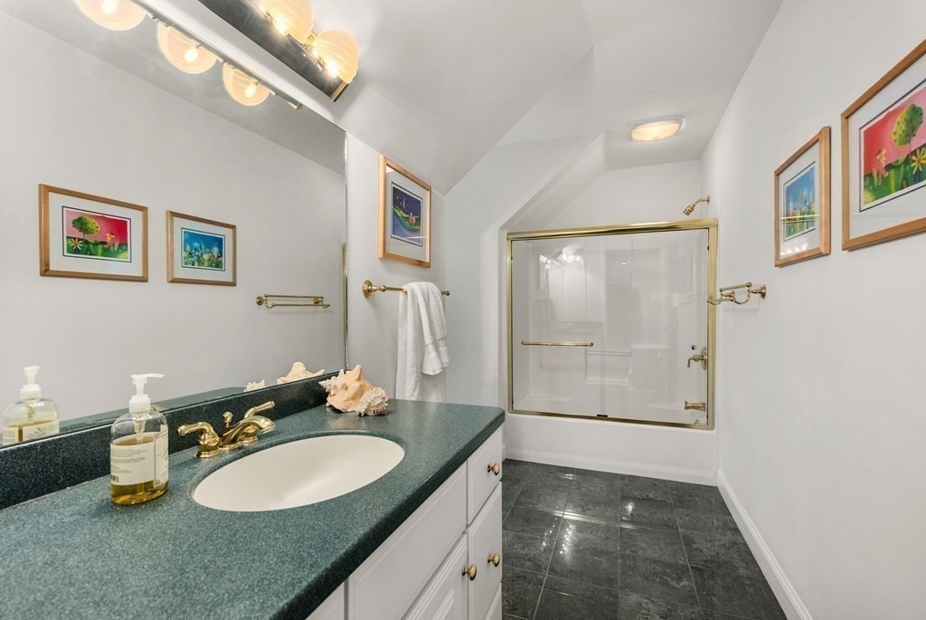28 Cutler Farm Road Sudbury, MA 01776 - Photo 28 of 42 a bathroom with a granite countertop sink a mirror a bathtub and shower