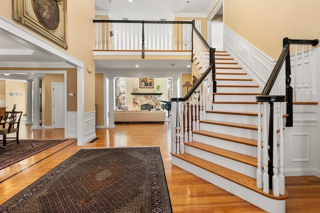 28 Cutler Farm Road Sudbury, MA 01776 - Photo 4 of 42 a view of staircase with lots of frames on wall and a dining table
