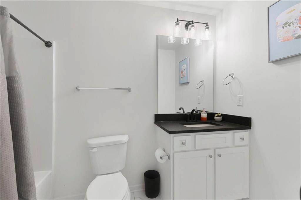 973 Mayson Turner Road Northwest Atlanta, GA 30314 - Photo 19 of 38 a bathroom with a granite countertop sink toilet and mirror