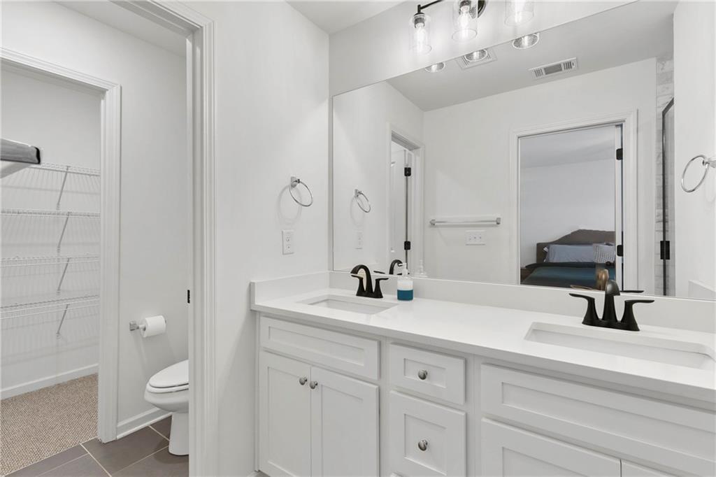 973 Mayson Turner Road Northwest Atlanta, GA 30314 - Photo 23 of 38 a bathroom with a double vanity sink toilet and a mirror
