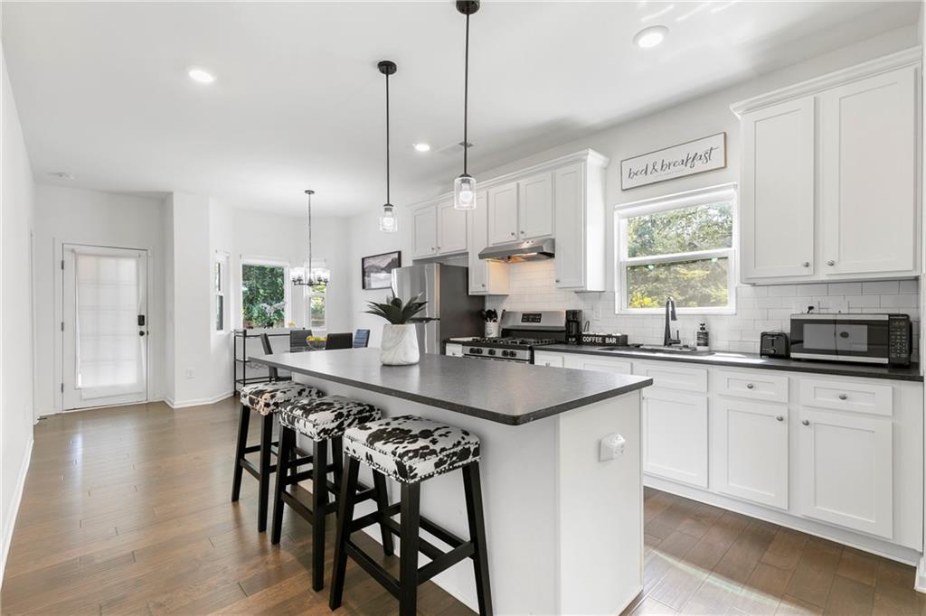 973 Mayson Turner Road Northwest Atlanta, GA 30314 - Photo 9 of 38 a kitchen with stainless steel appliances kitchen island a table chairs sink and cabinets