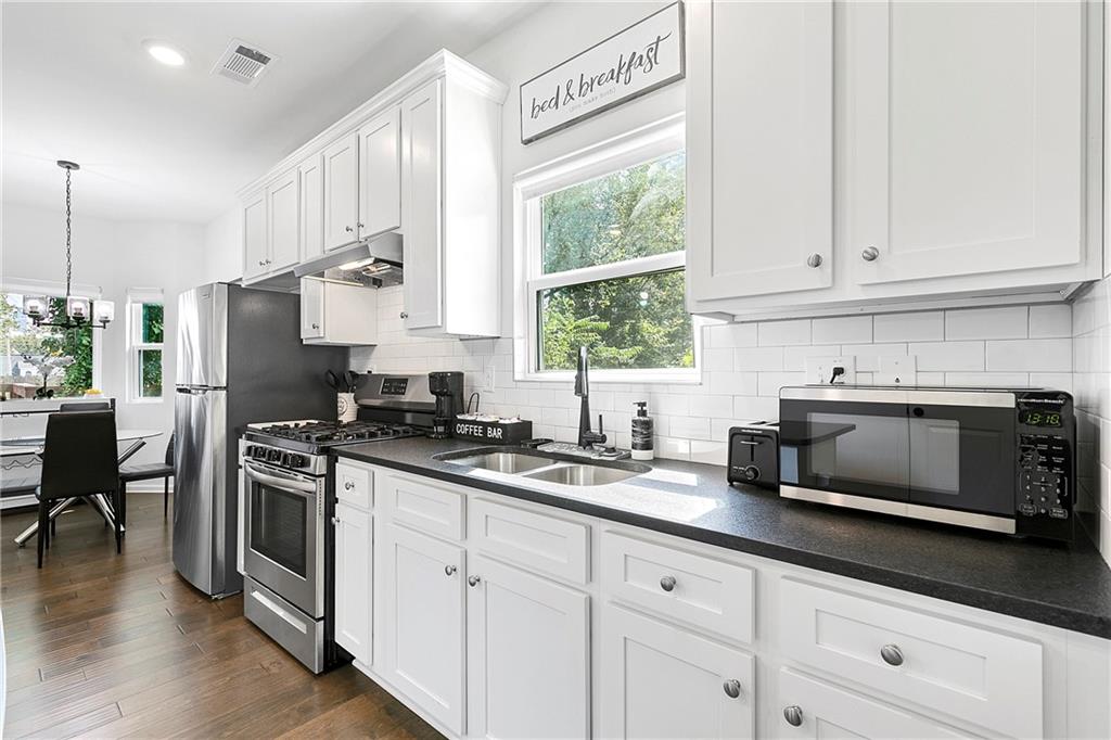 973 Mayson Turner Road Northwest Atlanta, GA 30314 - Photo 10 of 38 a kitchen with stainless steel appliances granite countertop a stove a sink and a microwave