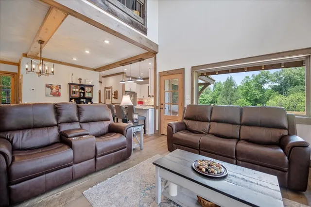 a living room with furniture a flat screen tv and a floor to ceiling window