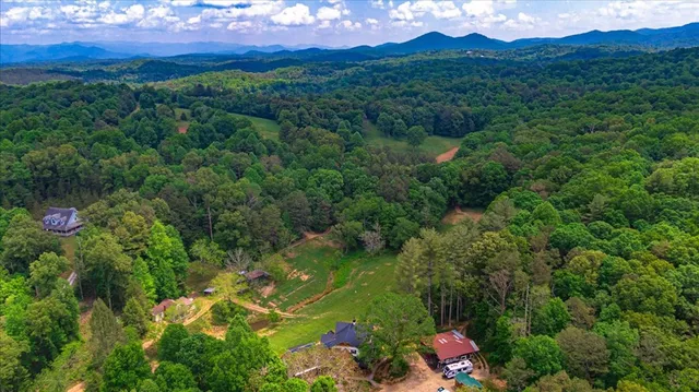 a dining hall with stainless steel appliances granite countertop a table chairs and a chandelier
