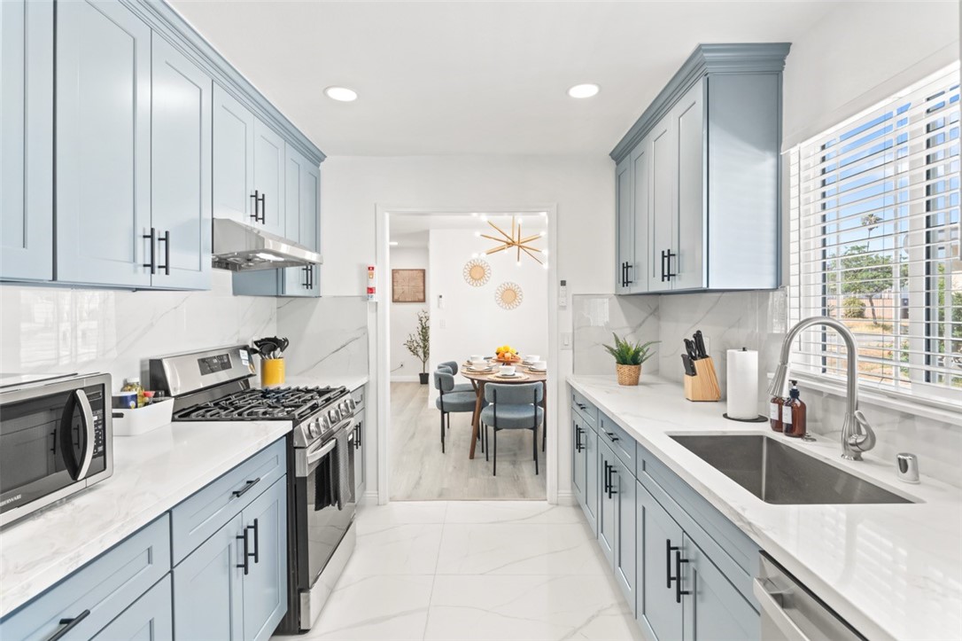9210 Ralph Street Rosemead, CA 91770 - Photo 47 of 59 a kitchen with kitchen island granite countertop a sink a counter space appliances and cabinets