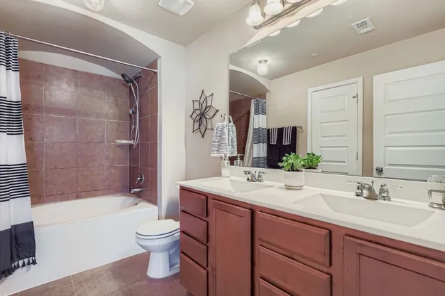 a bathroom with a sink vanity mirror bathtub shower and a toilet