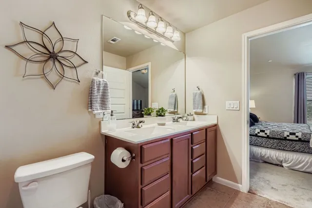 a bathroom with a toilet a sink a mirror and shower