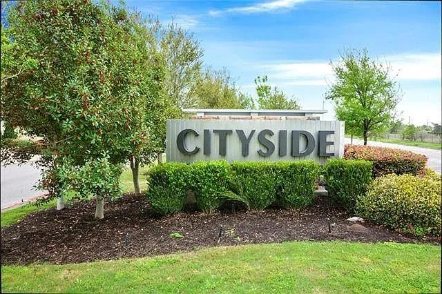 a sign that is sitting in front of a tree