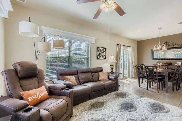 a living room with furniture ceiling fan and a window