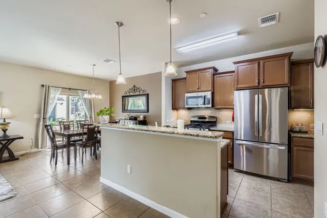 a kitchen with kitchen island a counter top space appliances and a dining table