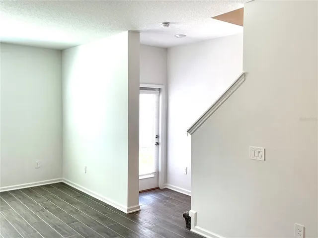 a view of an empty room with wooden floor