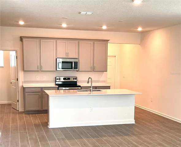 a kitchen with stainless steel appliances granite countertop a stove a sink and a microwave