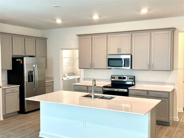a kitchen with stainless steel appliances granite countertop a sink stove and refrigerator