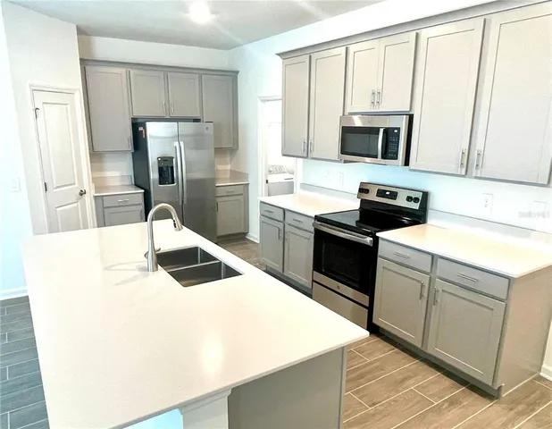 a kitchen with stainless steel appliances a stove microwave and refrigerator
