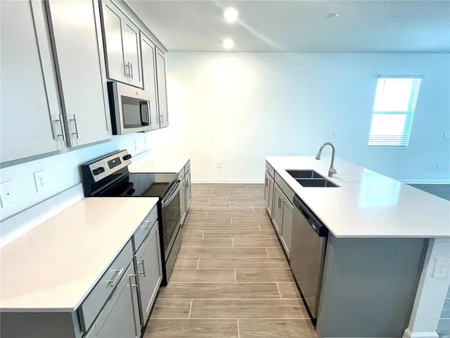 a kitchen with stainless steel appliances a sink stove and cabinets