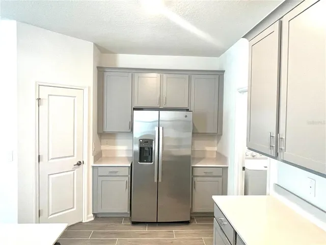 a kitchen with a refrigerator sink and cabinets