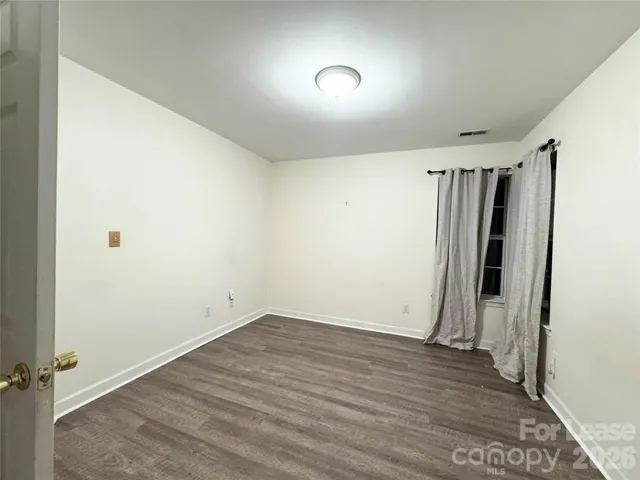 an empty room with wooden floor and window