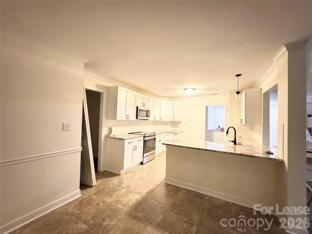 a large kitchen with kitchen island a sink stainless steel appliances and cabinets