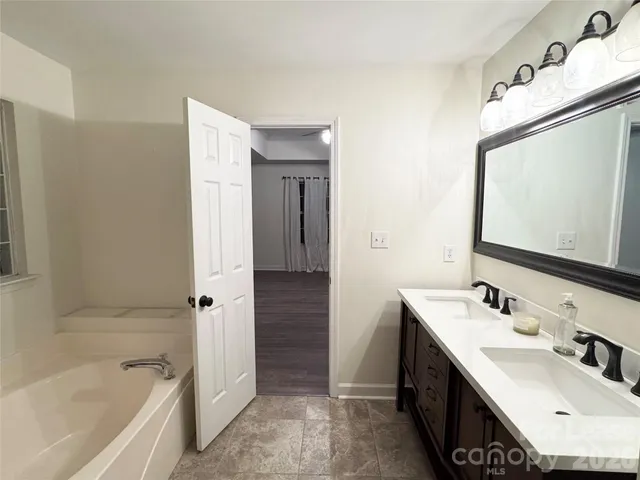 a bathroom with a tub sink and mirror
