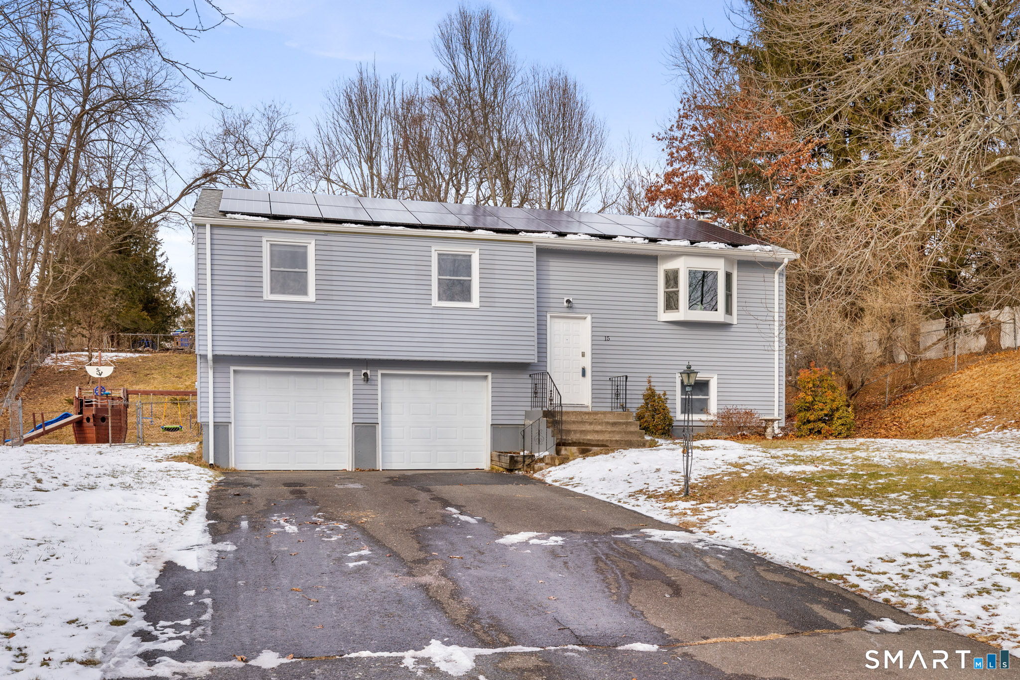 a front view of a house with a yard covered in snow