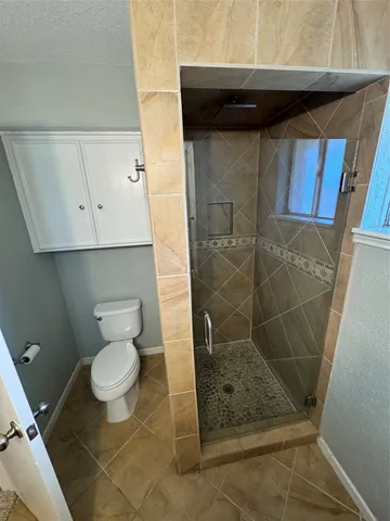 a bathroom with a toilet and a shower