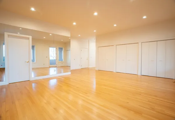 a view of an empty room with wooden floor
