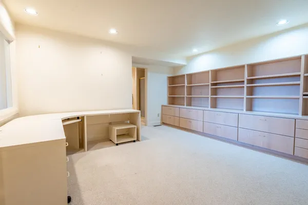 a view of an empty room with cabinet and a window
