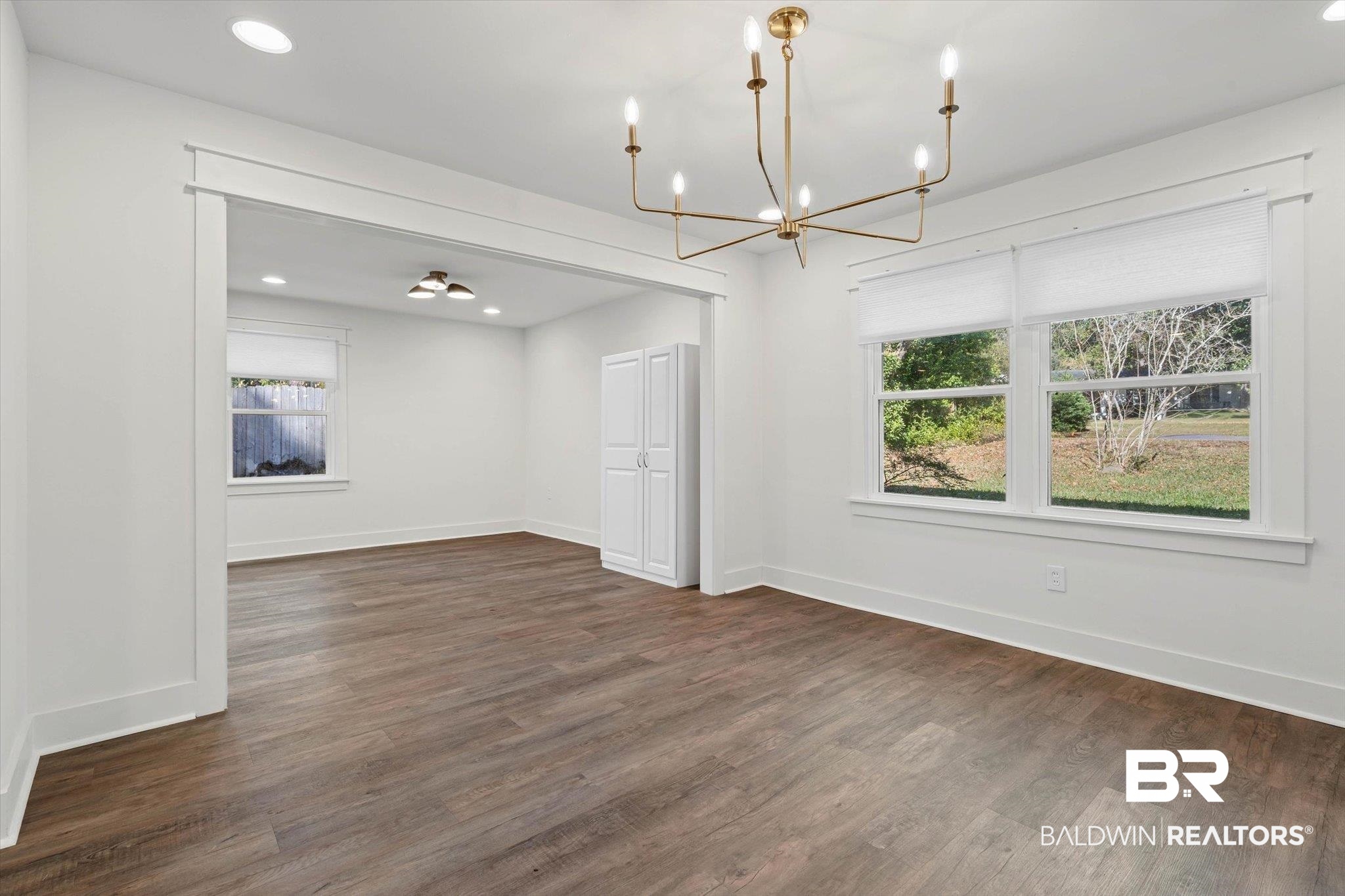 3933 Radnor Avenue Mobile, AL 36608 - Photo 9 of 36 Featuring recessed lighting, dark wood-style floors, and a chandelier, this area shows off the attention to detail during the renovation. The showstopper kitchen not to be missed!