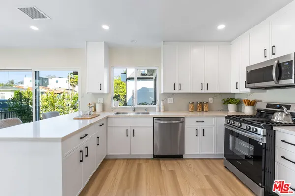 a kitchen with granite countertop a sink stainless steel appliances and cabinets
