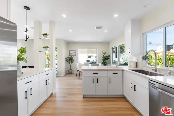 a large kitchen with stainless steel appliances kitchen island granite countertop a sink and cabinets