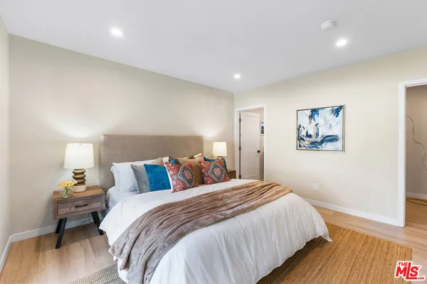 a bedroom with a bed and wooden floor