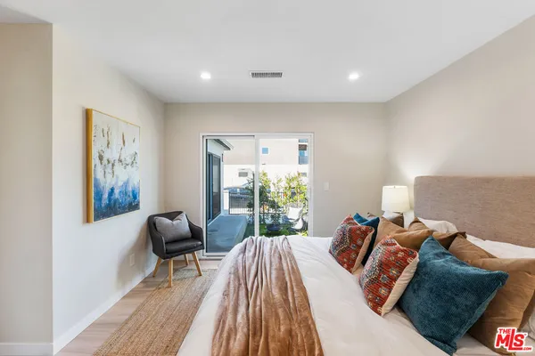 a bedroom with furniture and a large window