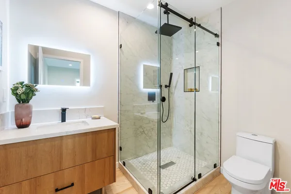 a bathroom with a granite countertop sink a toilet and shower