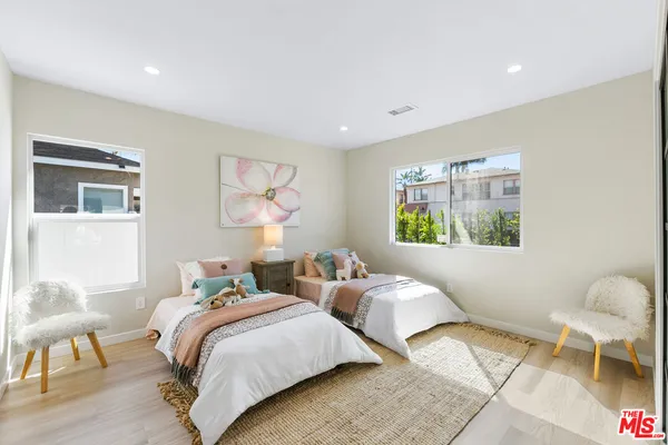 a bedroom with two beds and a painting on the wall