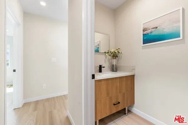 a room with painting on the wall and a potted plant