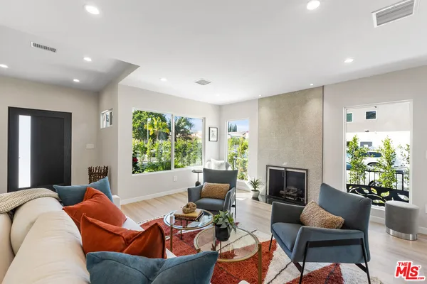 a living room with furniture fireplace and a large window
