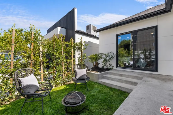 a view of a chair and table in backyard of the house